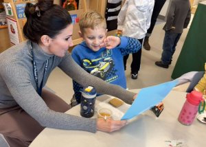While enjoying a snack, Little Vikings student Dameon Patrick practices some skills with guidance from Sarah Pisacano, school psychologist.