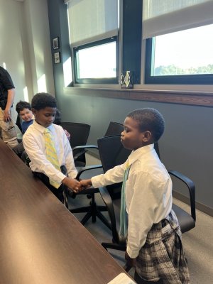 Messiah Long, left, and E’maurei Wise practice shaking hands.