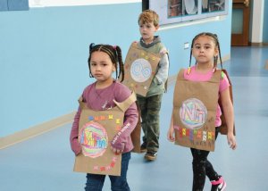 Heading toward the first-grade wing to sing the alphabet song are (l-r) kindergarteners Sophia May, Tobias Ostash and Alayah Miller.