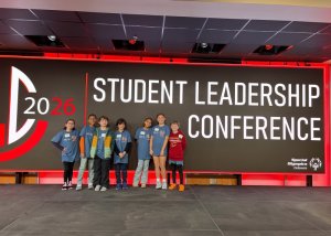 Love Creek Elementary School students gathered on the stage in front of the leadership conference banner are (l-r) Zelie Zimmer, Chance Everson, Zane Derti, Javier Ruiz, Naomi Rodriguez, Gabby Getz and Ben Kuns.