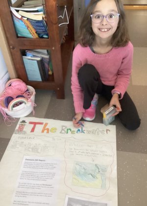 Gia Anthenelli shares a big smile as she works on her poster about the Delaware Breakwater.