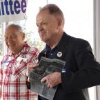 Paul Kuntzler shows a newspaper clipping where he can be identified greeting John Kennedy at an airport on the tarmac.