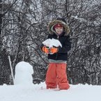 Lillian Hosler is clearly having fun building a snowman.