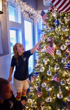 Olivia Nehrbas searches for an ornament with a relative’s name on the veterans Christmas tree at Lewes Yacht Club. RON MACARTHUR PHOTOS