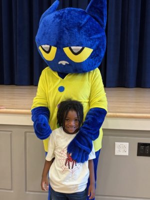 Jeremias Floyd stands with Pete the Cat for a photo.