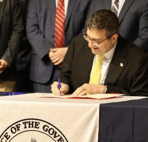 Gov. Matt Meyer signs an executive order Feb. 26. OFFICE OF THE GOVERNOR PHOTO
