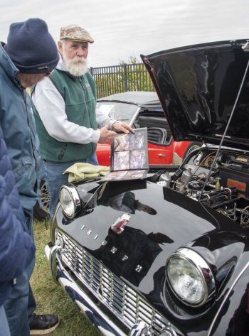 Dennis Morrison shows off photos of his 1960 Triumph's restoration.